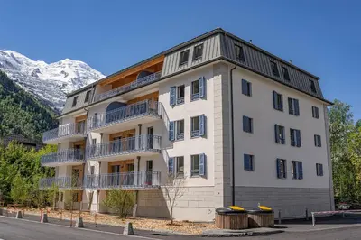 a large white building with a mountain in the background at Paradisa Penthouse in Chamonix-Mont-Blanc