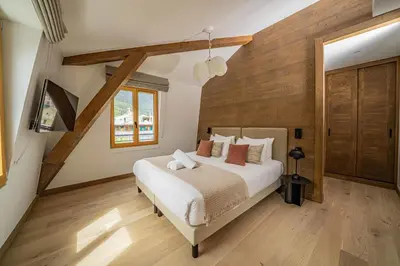 a bedroom with a large bed and wooden walls at Paradisa Penthouse in Chamonix-Mont-Blanc