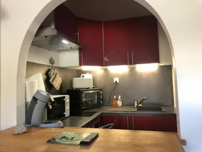 a kitchen with red cabinets and a table with a microscope at OLCA Les Houches in Les Houches