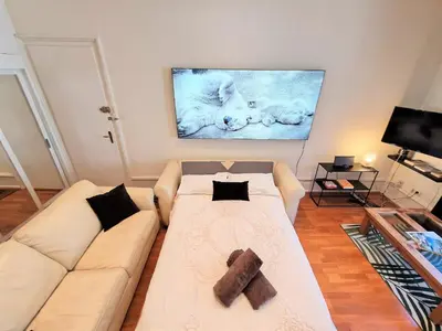 a living room with a white couch and a tv at Le Majestic Superbe Appartement Centre Chamonix in Chamonix-Mont-Blanc