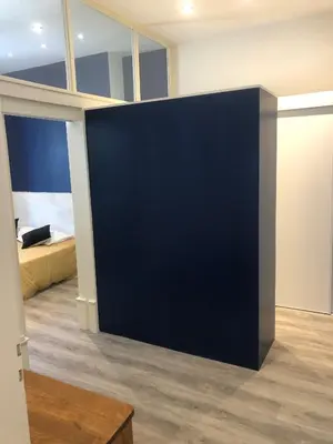 a large blue wall in a room with a bed at Le Majestic Superbe Appartement Centre Chamonix in Chamonix-Mont-Blanc