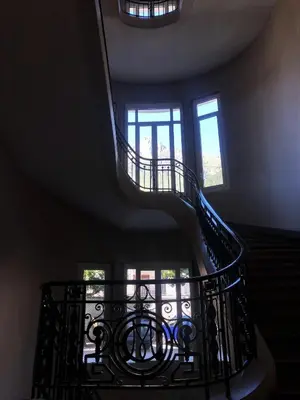 a spiral staircase in a building with a window at Le Majestic Superbe Appartement Centre Chamonix in Chamonix-Mont-Blanc