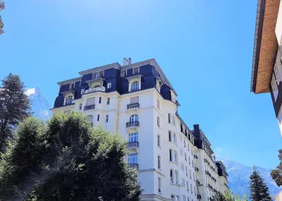 a tall white building with a black roof at Le Majestic Superbe Appartement Centre Chamonix in Chamonix-Mont-Blanc
