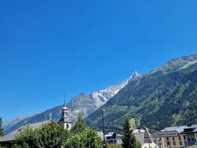 a town with a church in front of a mountain at Le Majestic Superbe Appartement Centre Chamonix in Chamonix-Mont-Blanc