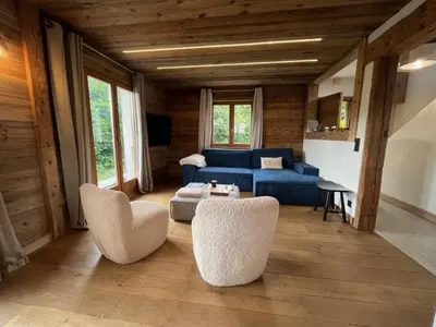 a living room with a blue couch and chairs at Chalet Taïga face au Montblanc et à 7min de Megève in Combloux