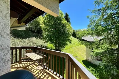 a balcony with a table and a bench on it at Les Tulipes Blanches in Megève