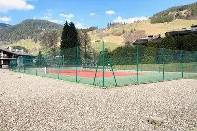 a tennis court with a tennis court at Les Tulipes Blanches in Megève