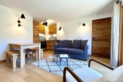 a living room with a blue couch and a table at Les Tulipes Blanches in Megève
