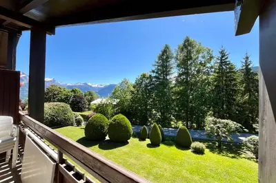 a balcony with a view of a garden at Les Toits des Cateaux in Combloux