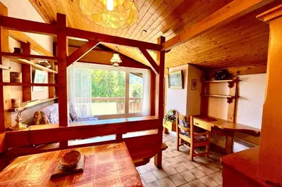 a room with a table and a window in a cabin at Les Toits des Cateaux in Combloux