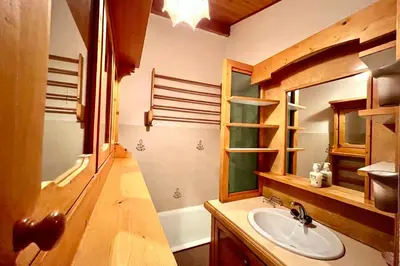 a bathroom with a sink and a mirror and a tub at Les Toits des Cateaux in Combloux