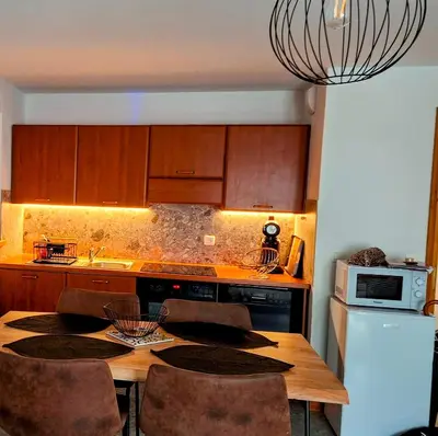a kitchen with a wooden table with chairs and a microwave at Appartement 14 - Résidence Conseil au coeur du village in Saint-Gervais-les-Bains