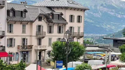 a large white building with a gray roof at Appartement 14 - Résidence Conseil au coeur du village in Saint-Gervais-les-Bains