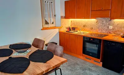 a kitchen with a wooden table with chairs and a sink at Appartement 14 - Résidence Conseil au coeur du village in Saint-Gervais-les-Bains
