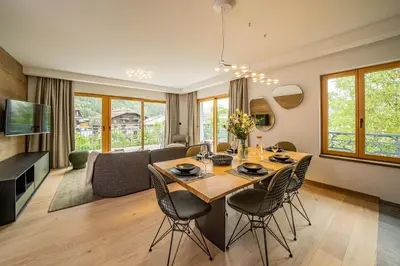 a dining room and living room with a table and chairs at Paradisa Terrasse Mont-Blanc Central 3-bedroom with Mont-Blanc View! in Chamonix-Mont-Blanc