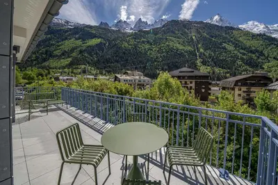 a balcony with a table and chairs and mountains at Paradisa Terrasse Mont-Blanc Central 3-bedroom with Mont-Blanc View! in Chamonix-Mont-Blanc