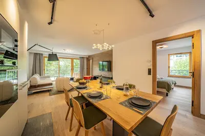 a dining room and living room with a table and chairs at Paradisa Mer de Glace Elegant brand new 3-bedroom apartment in Chamonix-Mont-Blanc