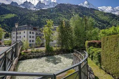 a bridge over a river with mountains in the background at Paradisa Mer de Glace Elegant brand new 3-bedroom apartment in Chamonix-Mont-Blanc