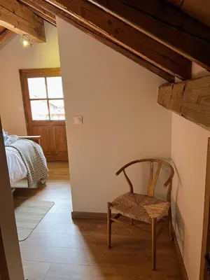 a chair in a room with a bed and a window at Chalet Tomsine in Samoëns