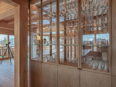 a glass display case with many glasses in it at Chalet 180 I Le Chalet Club in Combloux