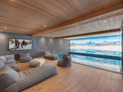a living room with couches and a large screen at Chalet 180 I Le Chalet Club in Combloux
