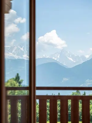 a view of the mountains from a window at Chalet 180 I Le Chalet Club in Combloux