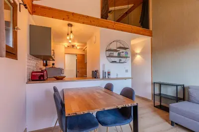 a kitchen and dining room with a wooden table and chairs at Appartement avec superbe vue montagne in Arâches-la-Frasse