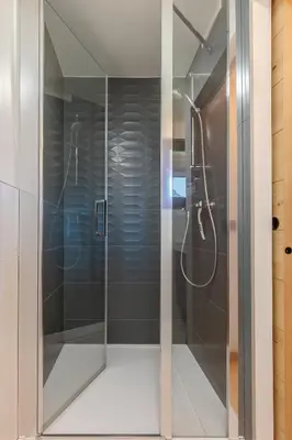 a shower with a glass door in a bathroom at Appartement avec superbe vue montagne in Arâches-la-Frasse