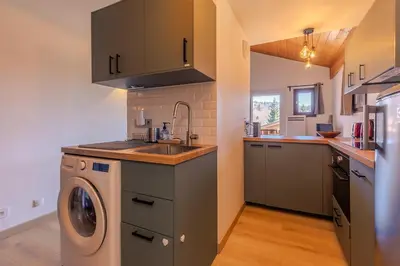 a kitchen with a sink and a washing machine at Appartement avec superbe vue montagne in Arâches-la-Frasse