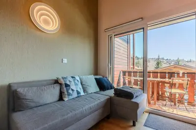 a living room with a couch and a large window at Appartement avec superbe vue montagne in Arâches-la-Frasse