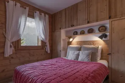 a bedroom with a bed with a red blanket and a window at Grande Jorasses 2 - Ski - Terrasse - Vue Montagne in Les Houches