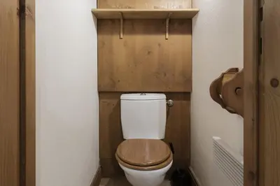 a small bathroom with a toilet with a wooden seat at Grande Jorasses 2 - Ski - Terrasse - Vue Montagne in Les Houches
