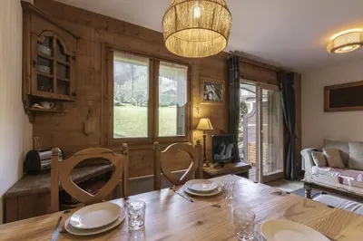 a dining room with a table and chairs and a couch at Grande Jorasses 2 - Ski - Terrasse - Vue Montagne in Les Houches
