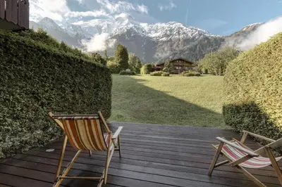 two chairs on a wooden deck with mountains in the background at Grande Jorasses 2 - Ski - Terrasse - Vue Montagne in Les Houches