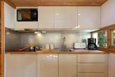a kitchen and living room with a table in a cabin at Résidence Grand Roc - Bruyères 220 - Happy Rentals in Chamonix-Mont-Blanc