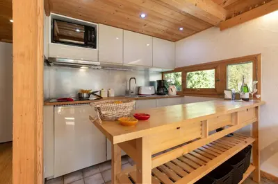 a kitchen and dining room with a table and chairs at Résidence Grand Roc - Bruyères 220 - Happy Rentals in Chamonix-Mont-Blanc