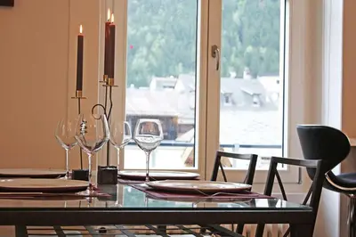 a dining room table with wine glasses and a window at Alpine Museum- Chamonix All Year in Chamonix-Mont-Blanc