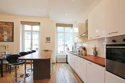a kitchen with white cabinets and a table and chairs at Alpine Museum- Chamonix All Year in Chamonix-Mont-Blanc