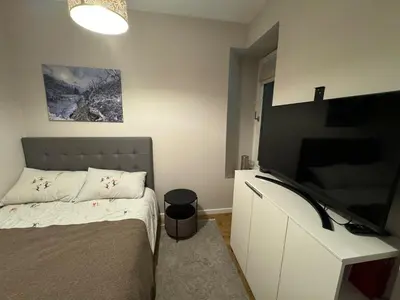 a bedroom with a bed and a flat screen tv at Chamonix city center rue Paccard in Chamonix-Mont-Blanc