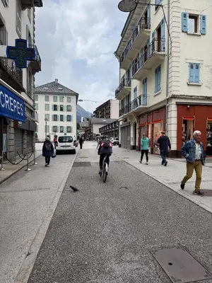 a group of people riding a bike down a street at Studio 4810 Centre Chamonix in Chamonix-Mont-Blanc