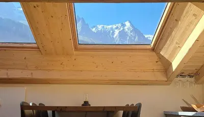 a window in a room with a table and a mountain at Le Top des Praz in Chamonix-Mont-Blanc