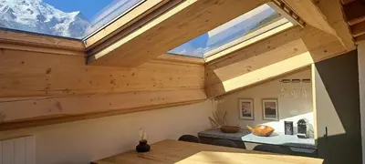 a room with a skylight in a house with a table at Le Top des Praz in Chamonix-Mont-Blanc