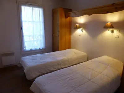 two beds in a hotel room with a window at Grand Panorama 1 bedroom - sleeps 4, Parking, Pool, Next to Ski Lift in Saint-Gervais-les-Bains