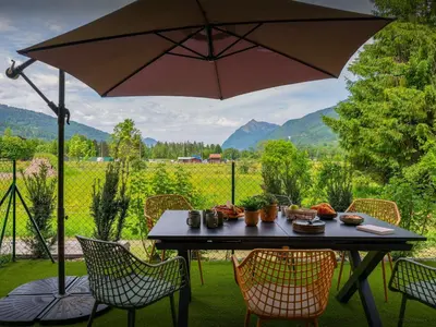 a table with an umbrella and chairs with a view at Lodge Sami - OVO Network in Samoëns