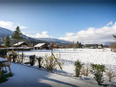 a snow covered yard with a fence and a snowy field at Lodge Sami - OVO Network in Samoëns