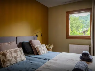 a bedroom with a bed and a window at Lodge Sami - OVO Network in Samoëns