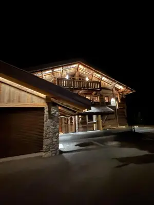 a wooden house with a garage at night at Chalet de Luxe - Centre-Ville in Megève