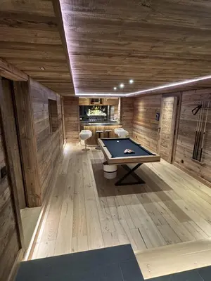 a pool table in a room with wooden walls at Chalet de Luxe - Centre-Ville in Megève