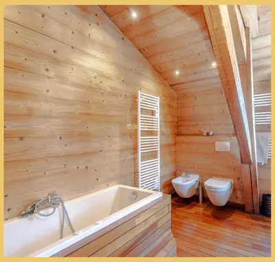 a bathroom with a tub in a wooden wall at Appartement La Comtesse I Centre de Saint-Gervais in Saint-Gervais-les-Bains