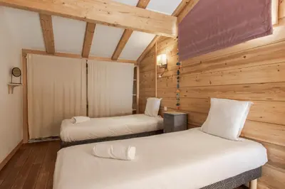 two beds in a room with wooden walls at Chalet du Verney - Pied du Prarion - Sauna in Les Houches
